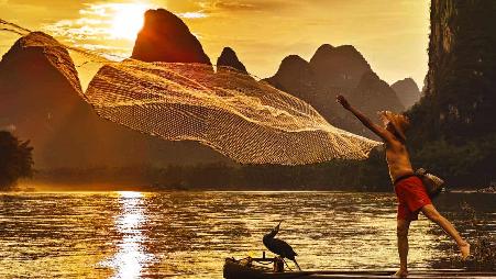 夕阳下的漓江，渔者正在撒网