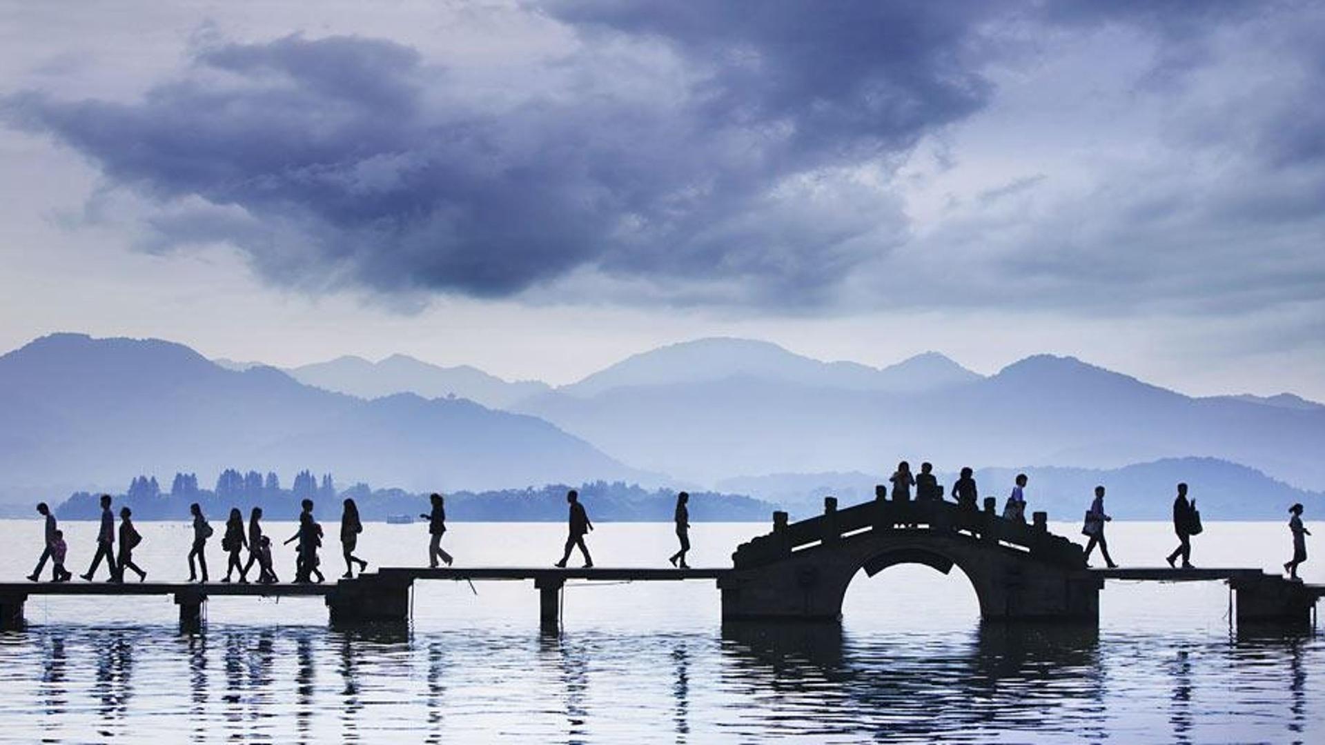 乌云下，西湖桥上的行人