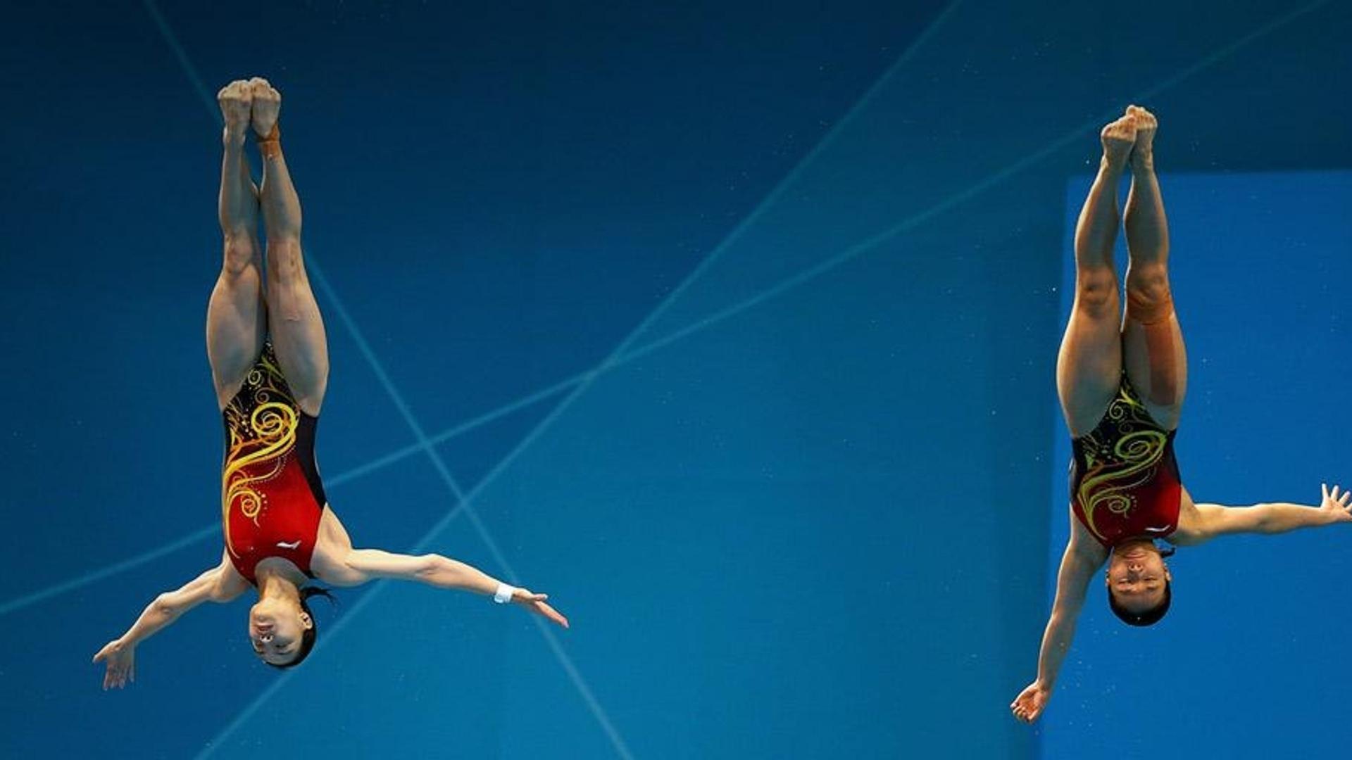 2012/7/29伦敦夏季奥运会，水上运动中心内女子双人3米跳板决赛中的吴敏霞与何姿