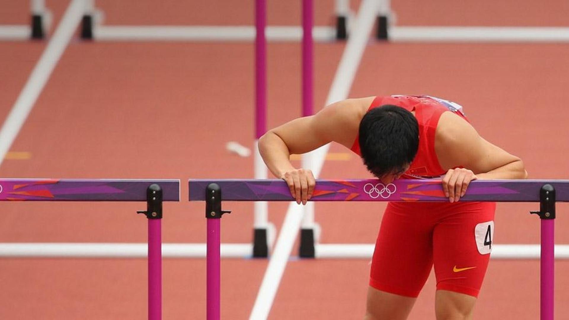 2012年8月7日伦敦奥林匹克体育场内男子110米栏预赛第一轮，刘翔伤后亲吻栏架