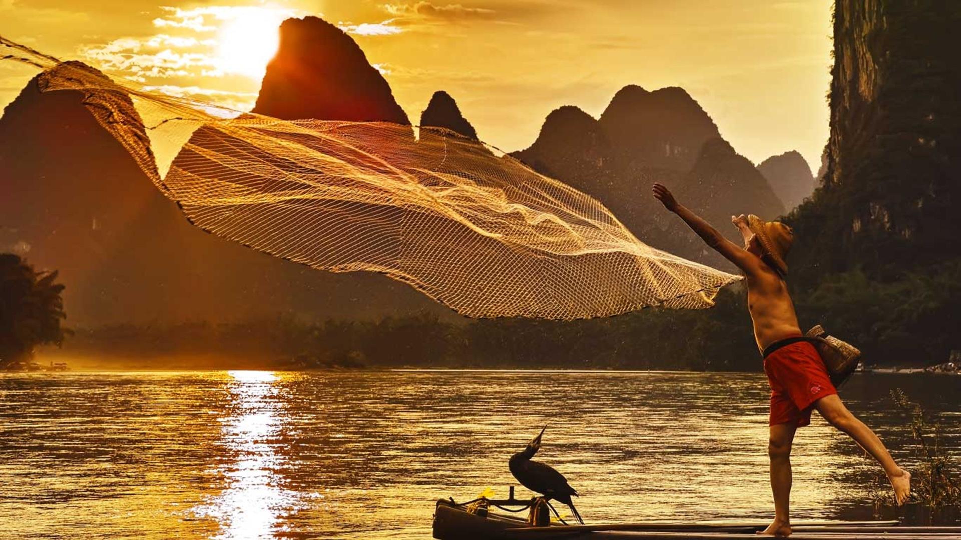 夕阳下的漓江，渔者正在撒网